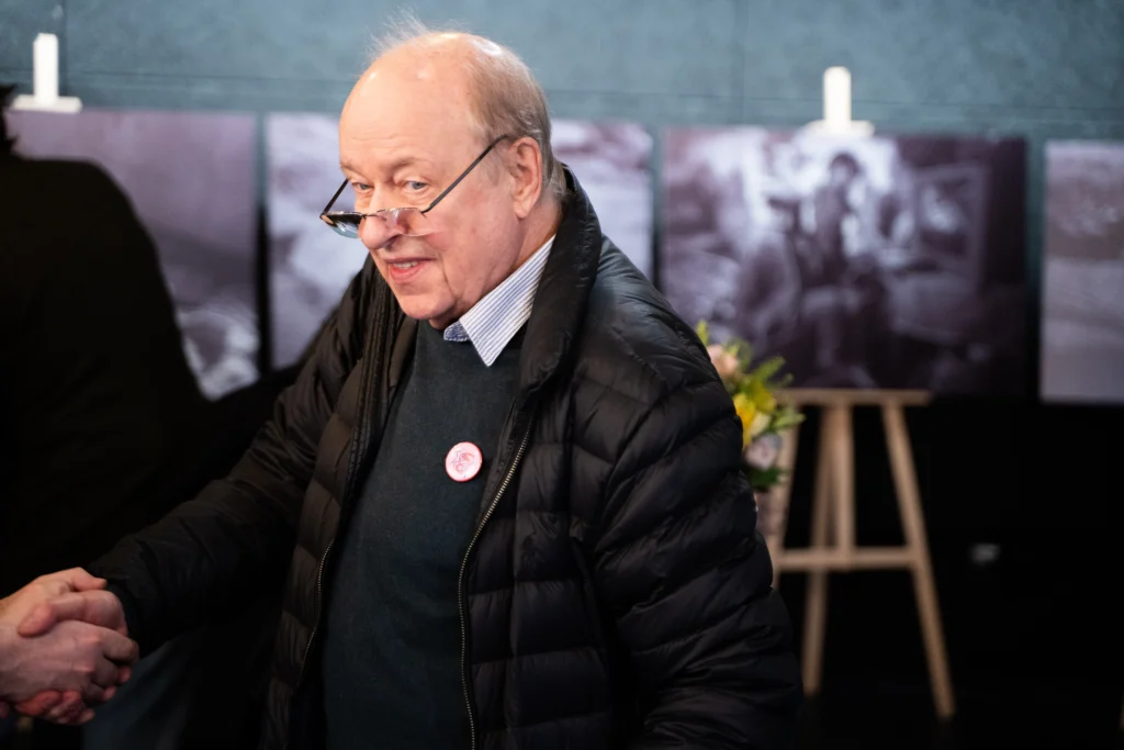 Wojciech Marczewski. W tle wystawa zdjęć z filmu Silver